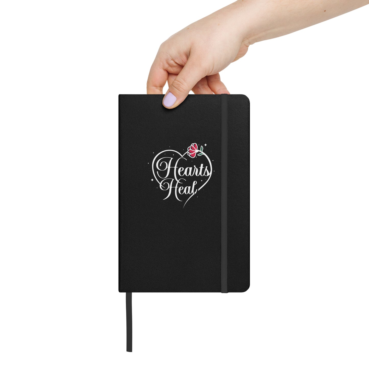 Black hardcover Hearts Heal Heart notebook held by a person.