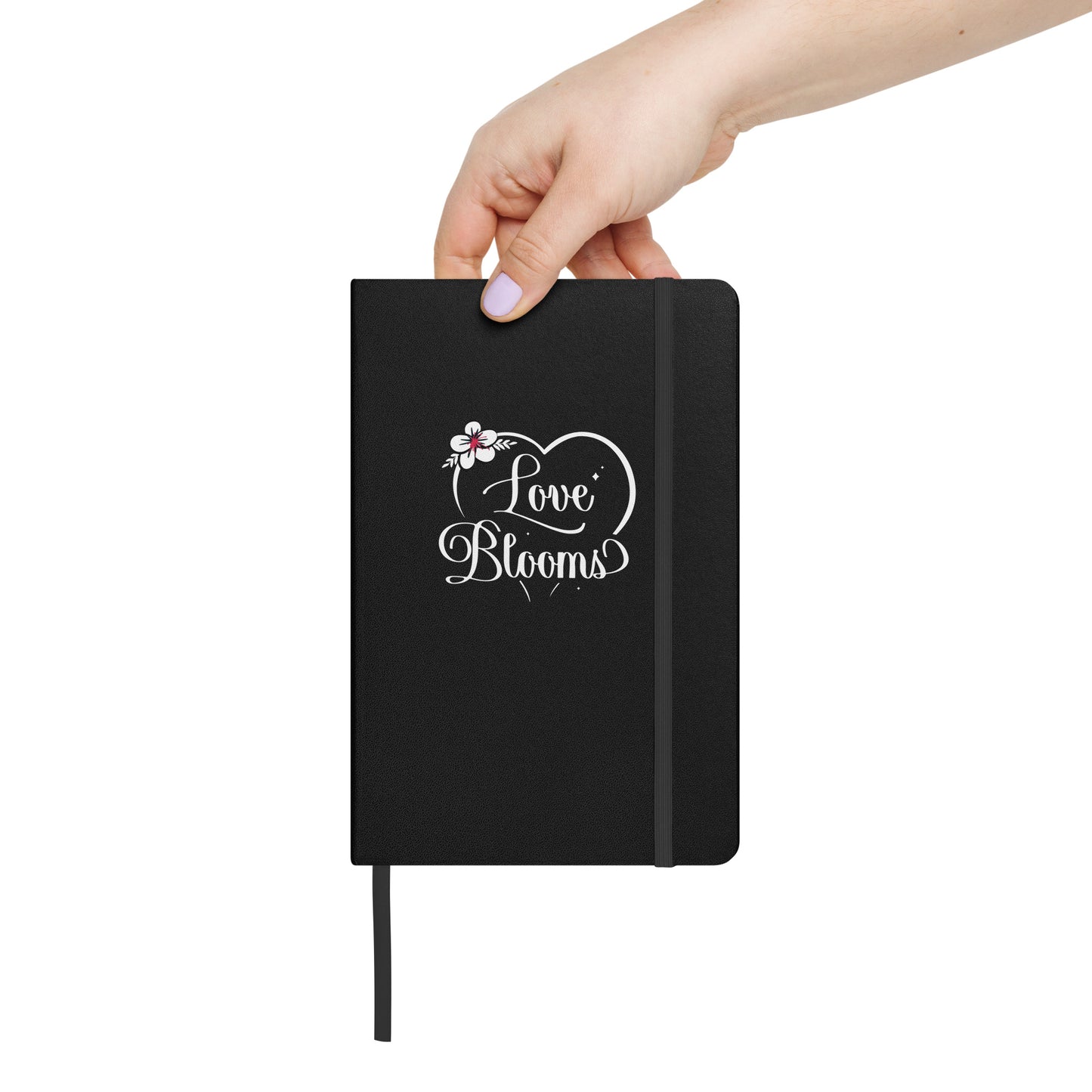 Black hardcover Love Blooms Heart notebook held by a person.