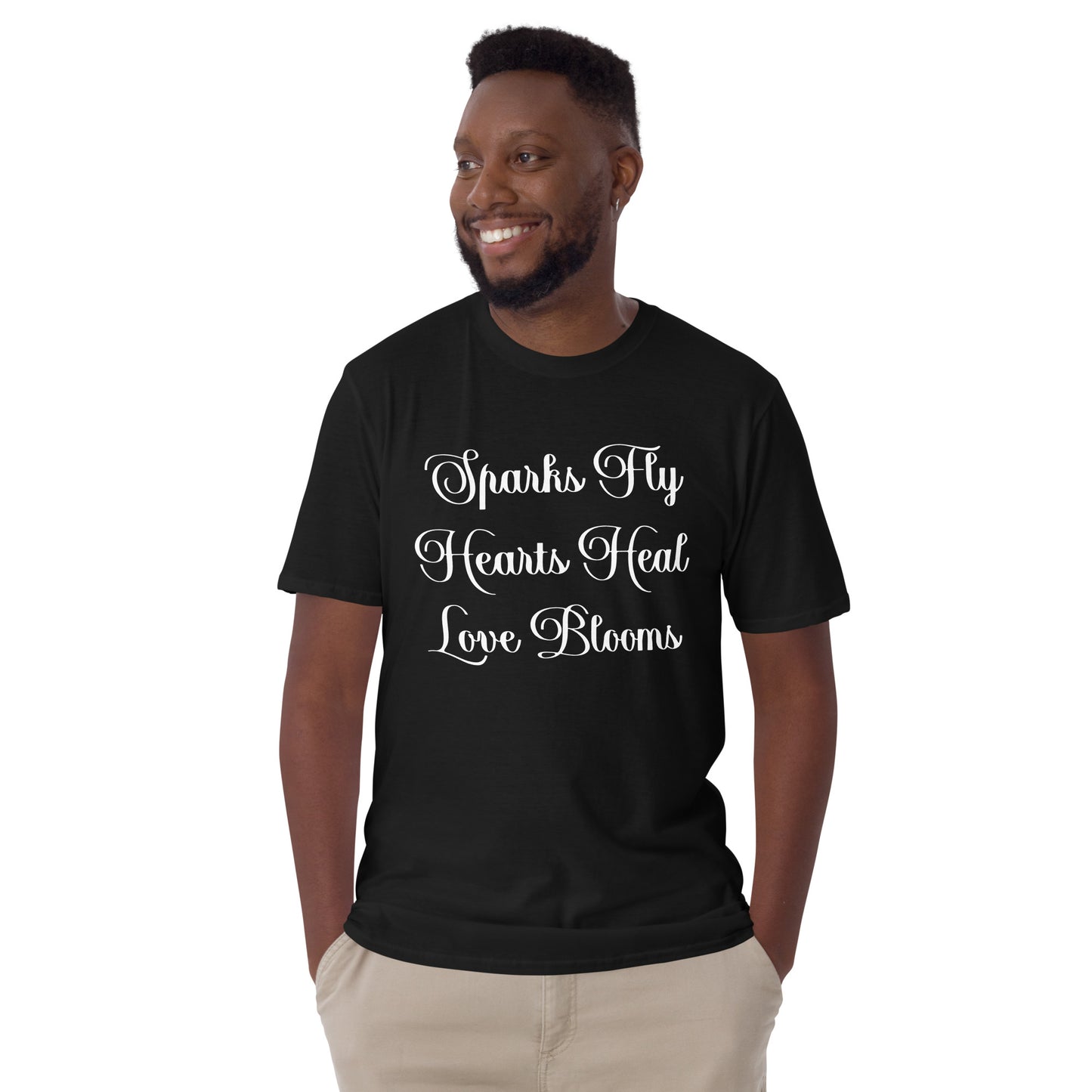 Smiling man wearing black Love's Journey Words t-shirt. Has the words Sparks Fly, Hearts Heal, Love Blooms.