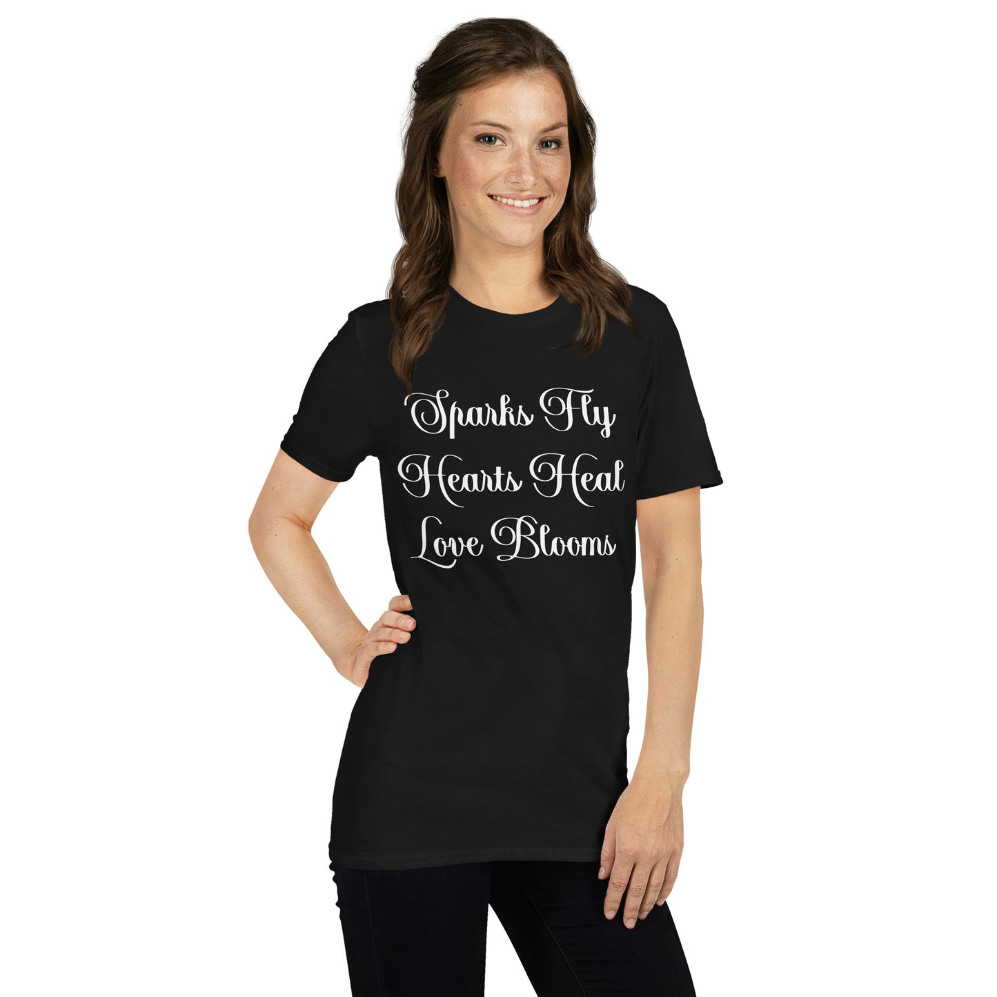 Smiling woman wearing black Love's Journey Words t-shirt. Has the words Sparks Fly, Hearts Heal, Love Blooms.