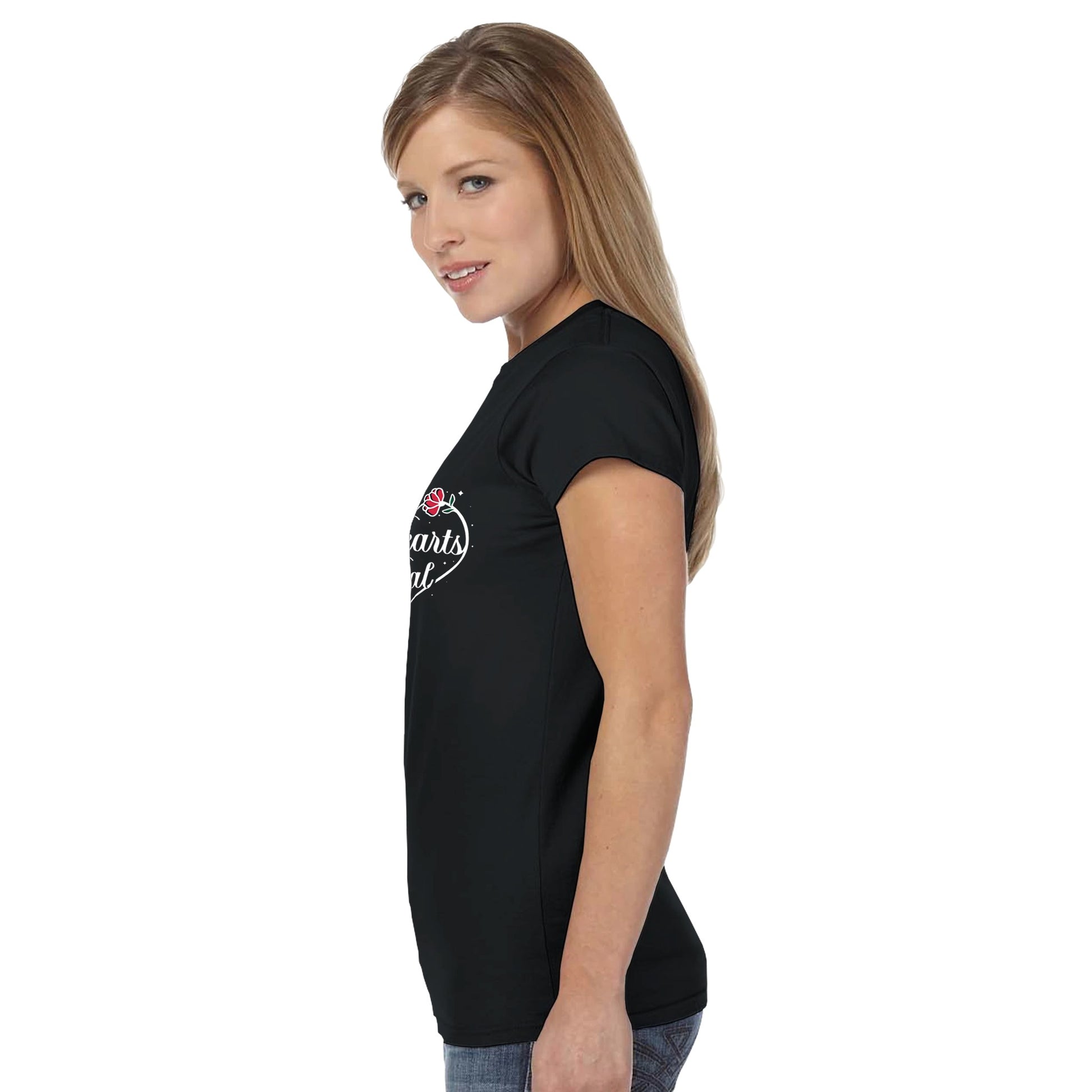 Woman turned to the side wearing a black t-shirt with Hearts Heal heart design.