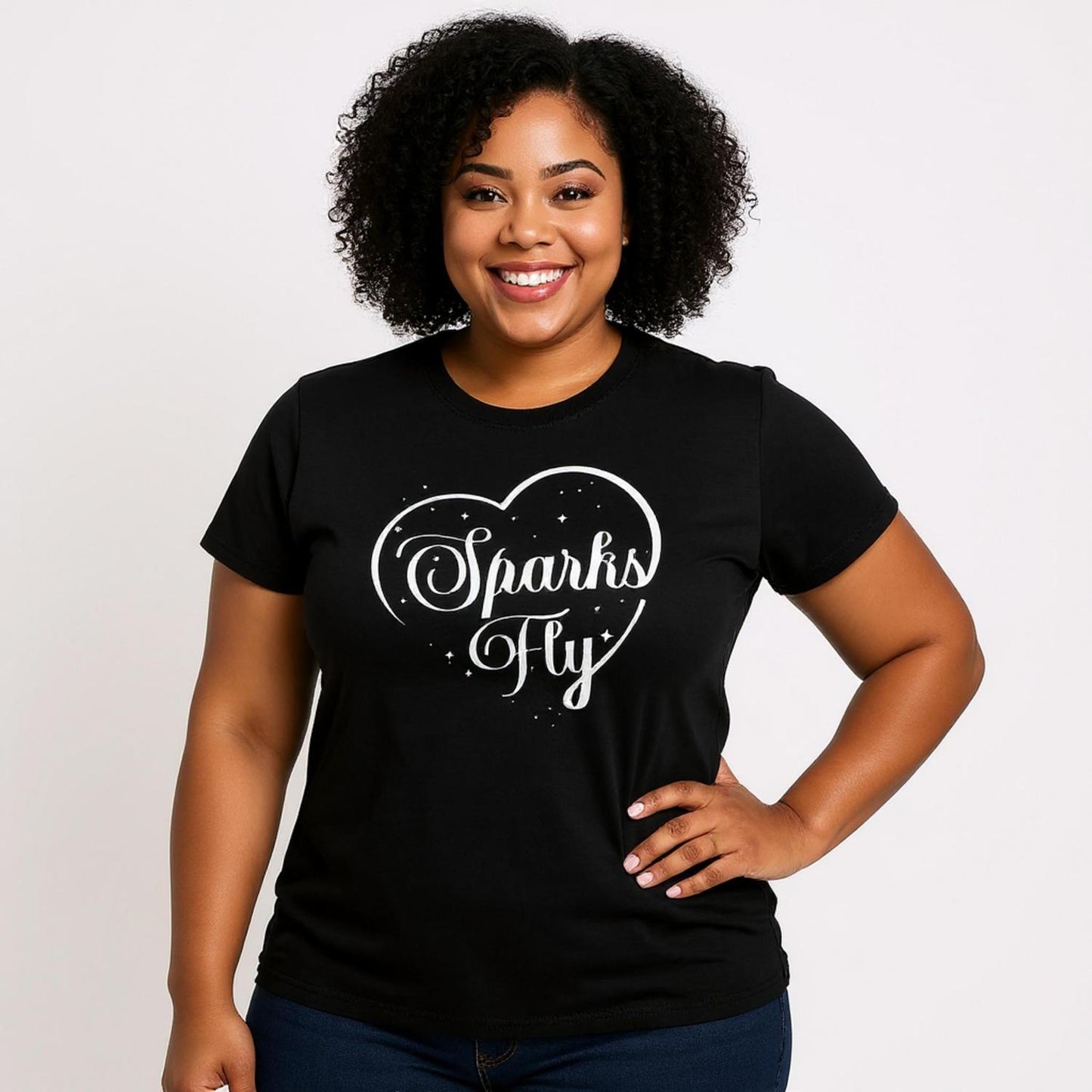 Woman wearing a short sleeved black t-shirt with Sparks Fly heart design.
