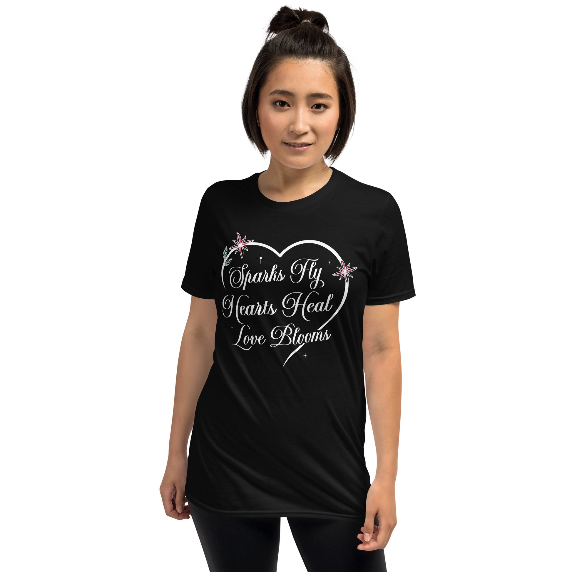 Woman wearing black Love's Journey Heart t-shirt. Heart with the words Sparks Fly, Hearts Heal, Love Blooms.